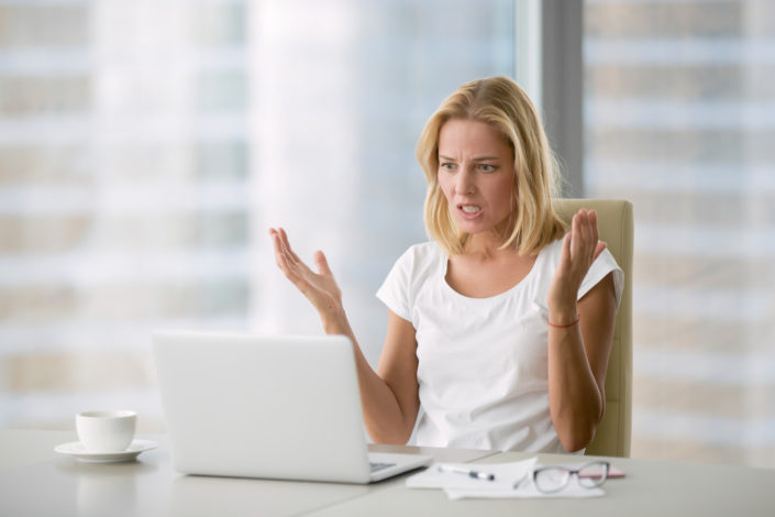 Frustrated Woman with Social Media Woman at laptop hands up in frustration over doing social media herself